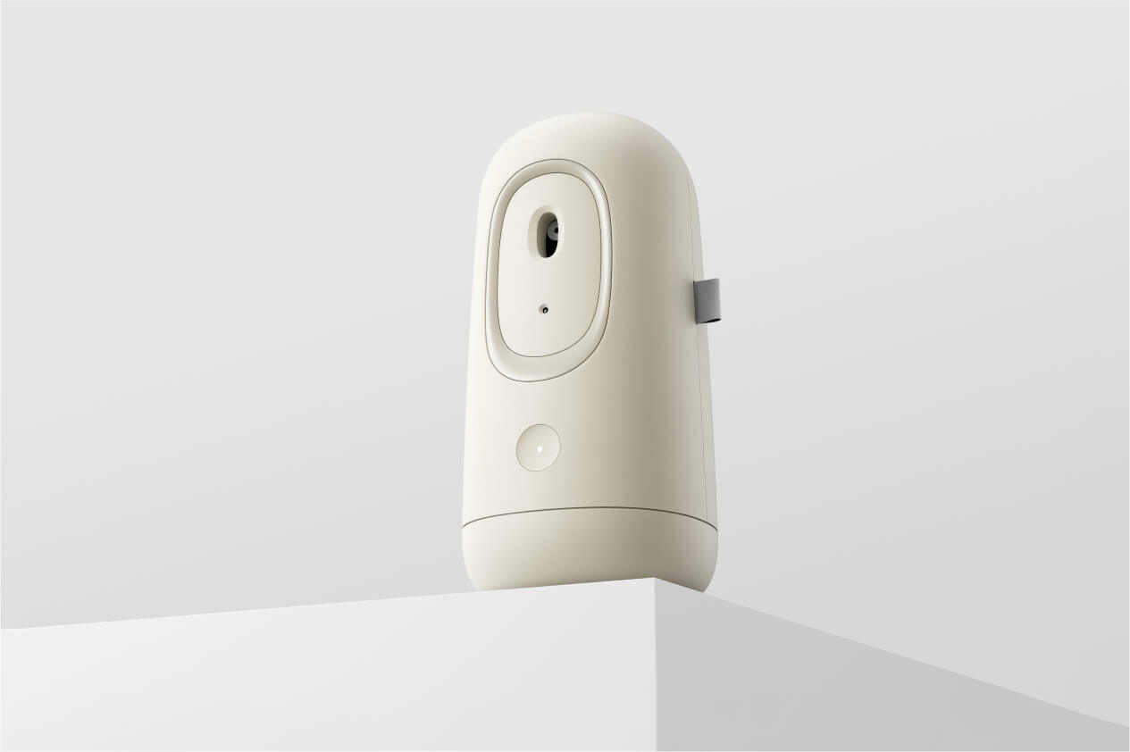 A beige automatic air freshener designed by Studio Copilot, placed on a white pedestal against a clean, neutral background.