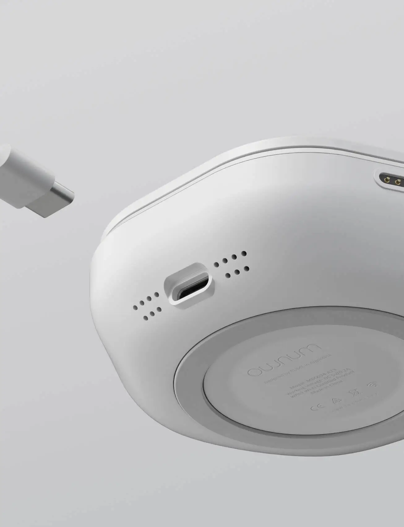 Close-up of the bottom side of a smart pill reminder device, showing a USB-C charging port and the "Ownum" branding.