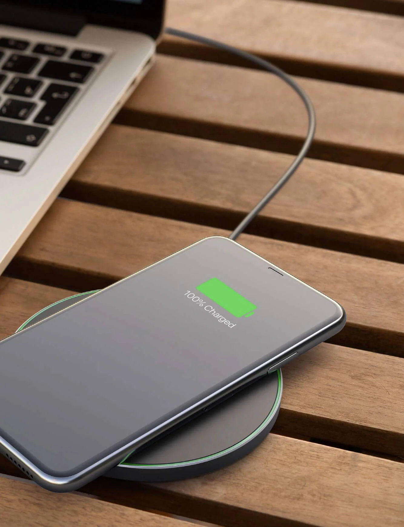 Photomontage of a wireless smartphone charger, a sleek black device placed on a desk.